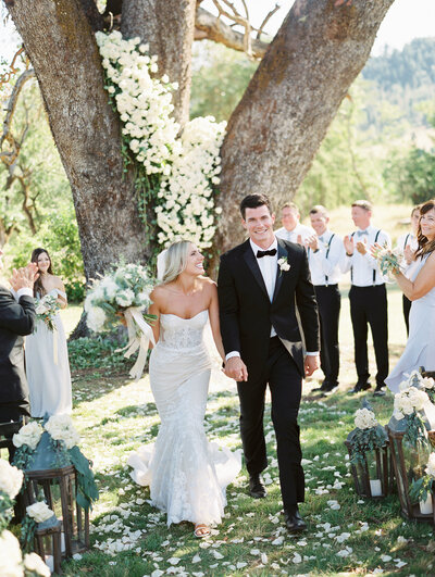 joyful bride and groom just pronounced husband and wife at their outdoor summer wedding