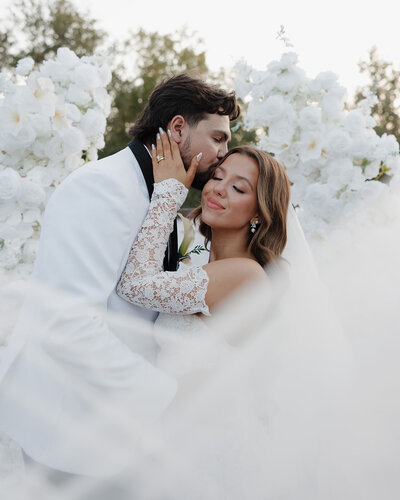 groom kisses bride on her cheek