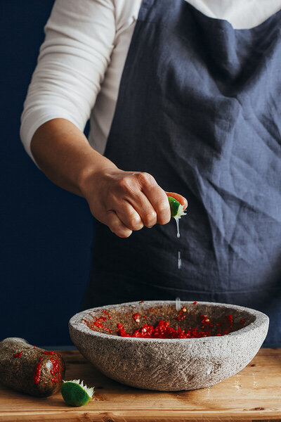 chef squeezing lime into a dish
