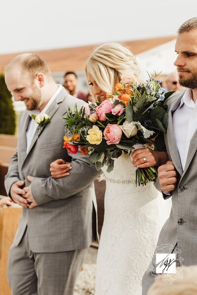 bride walking down the isle with groomsmen