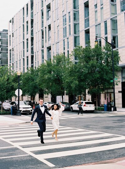 Bride and groom crossing the road holding hands