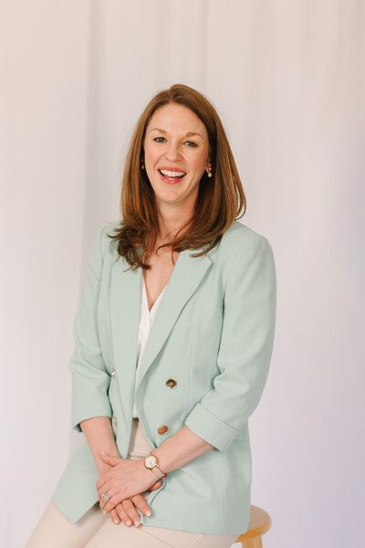 Lindsay smiling in a green blazer
