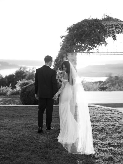 Bride and groom walking hand in hand outdoors during sunset, planned by Westmore Events in Texas Hill Country.