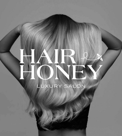 Black and white image of woman holding up long hair with the words 'Hair and Honey Luxury Salon' overlayed