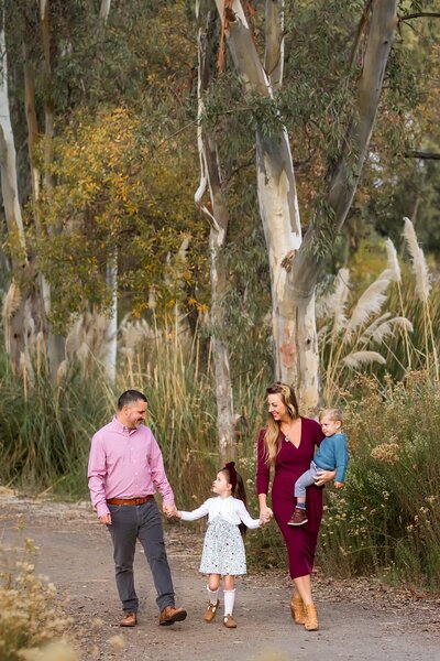 Family walking in a tree grove in San Diego