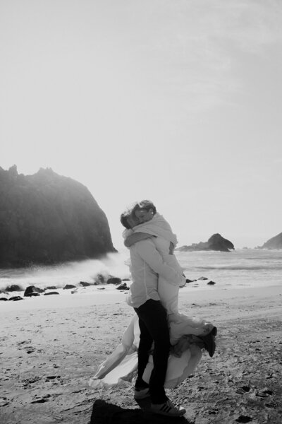 Wedding couple joyfully hugging at the beach