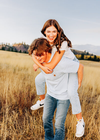 Engagement photo of couple doing piggy back at Blue Mountain Trailhead in Missoula, MT