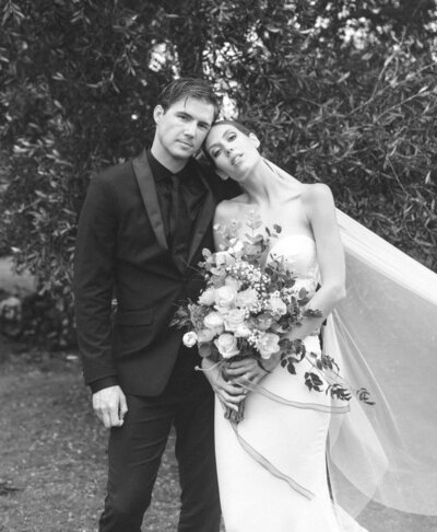 bride and groom standing on rocks embracing