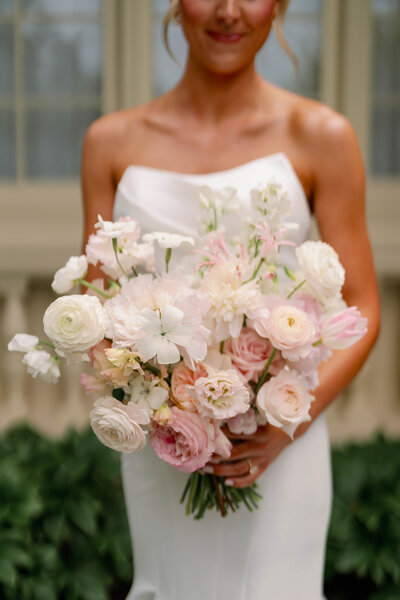 Outdoor table setting with pastel flowers, pink balloons backdrop.