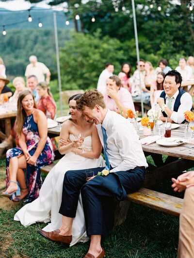 Bride and groom laugh during their reception speeches with guests at Paint Rock Farm by photographer My Sun and Stars Co.