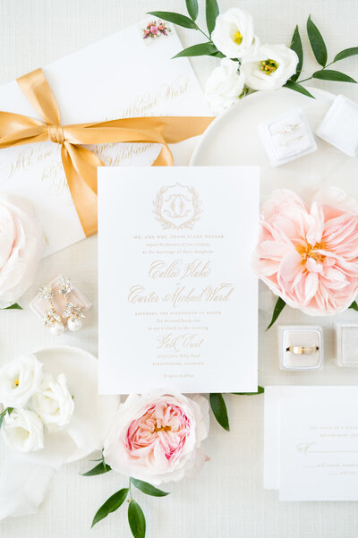Closeup of gold and pink wedding invitations.
