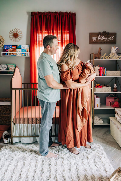 Beautiful warm nursery with a serene photo of the parents holding thier new baby girl in thier home near st. petersburg fl