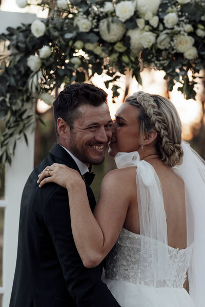 Bride and Groom wrapped in a veil, kissing it's black and white and has vibes of gone with the wind!