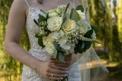 Bride holding wedding bouquet in a park STL