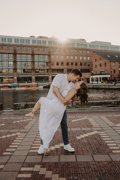 A person dipping their partner as they stand next to a river 