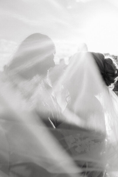 Bride and groom draped under wedding veil in downtown Minneapolis wedding