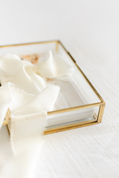 A Northern Virginia Newborn Photography photo of a glass box of prints to store your photos in