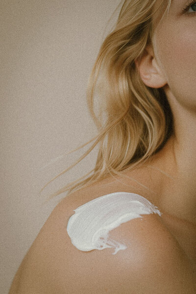 a woman's shoulder with skincare cream on it