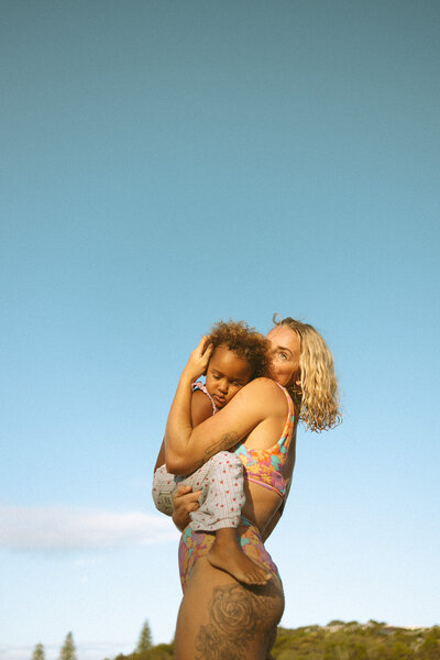 women holding her daughter in the sunshine of the beach in Evans Head