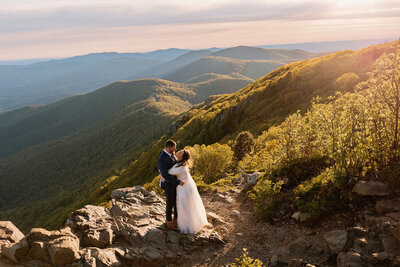 A couple stands at Stony Man summit during their hiking sunrise elopement in Shenandoah National Park