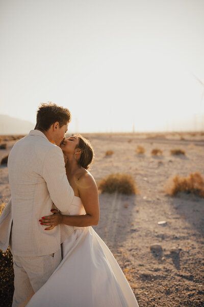 Couple kissing at sunset amongst windmills in palm springs