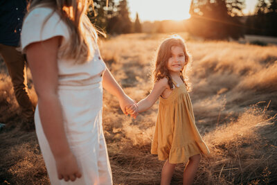 little girl holding sisters hand
