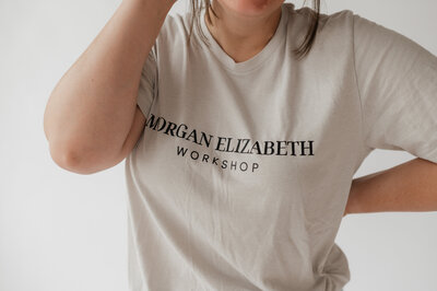A close up of someone wearing a shirt that reads "Morgan Elizabeth Workshop"