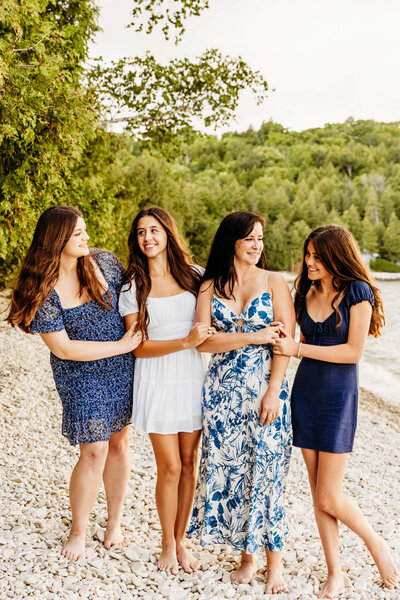 mom and three daughters laughing on a beach in Door County