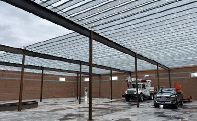 Photo of warehouse with steel beams and a service truck