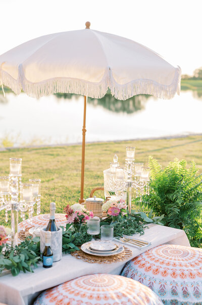 Picnic set up by the water with an umbrella overhead