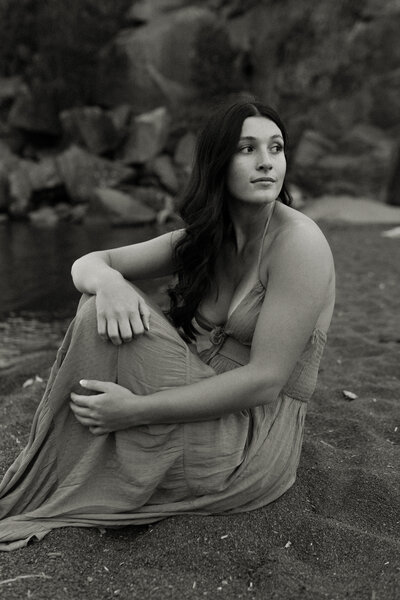 Minnesota senior girl sits along Black Beach in Silver Bay as the lake rushes to shore.
