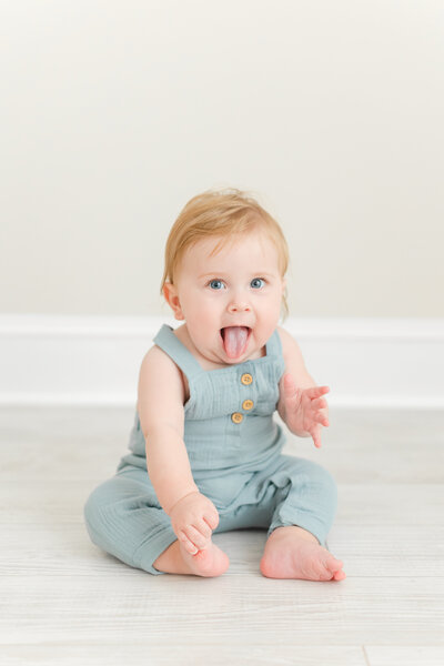 A photo of a baby boy smiling with his tongue sticking out by northern va family photographer