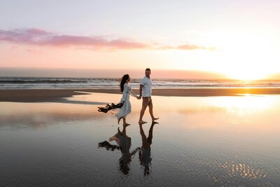man and woman walking on beach