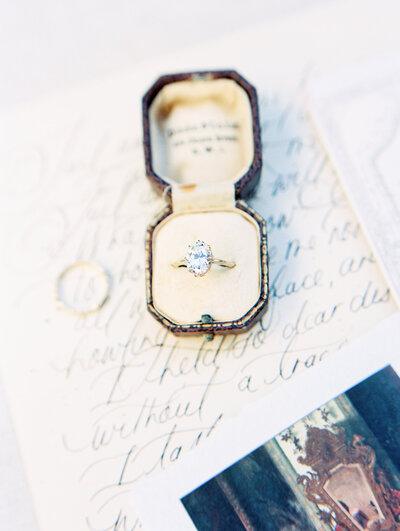 a wedding ring in a vintage case with a paper full of calligraphy by colorado wedding photographer JKG photography