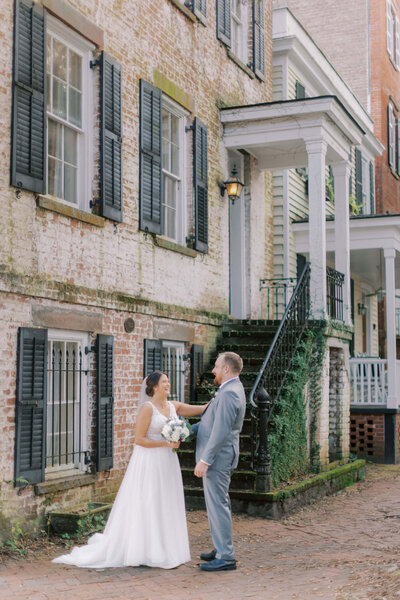 Bride and groom sharing a first look on Jones Street in Savannah's historic district, surrounded by brick architecture and historic charm.