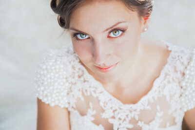 A bride poses on an elegant bed for her bridal session.