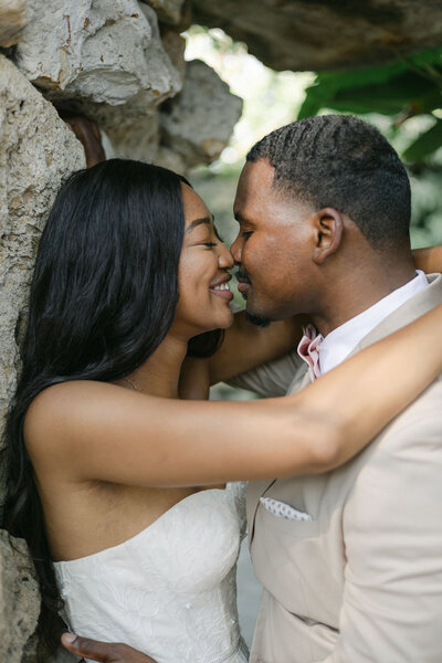 Black bride and groom nuzzle noses as the groom embraces her for a kiss. Sarasota wedding photos that are romantic and sweet.
