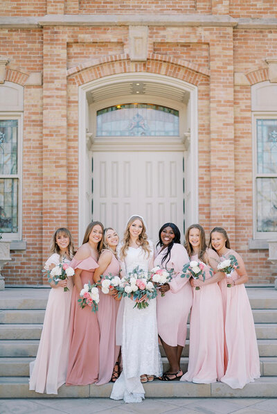 bride and bridesmaids standing in front of church