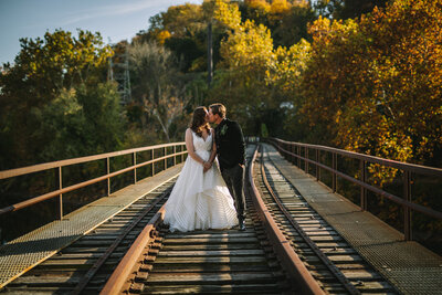 Couple kissing on a railroad bridge in the autumn in Philadelphia.