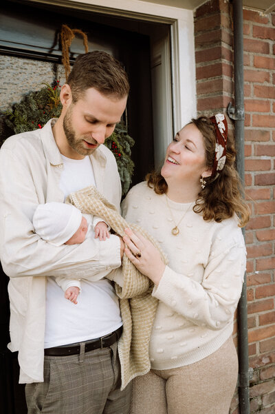 Gezin met newborn bij de voordeur van hun huis – lifestyle fotografie vol thuisgevoel