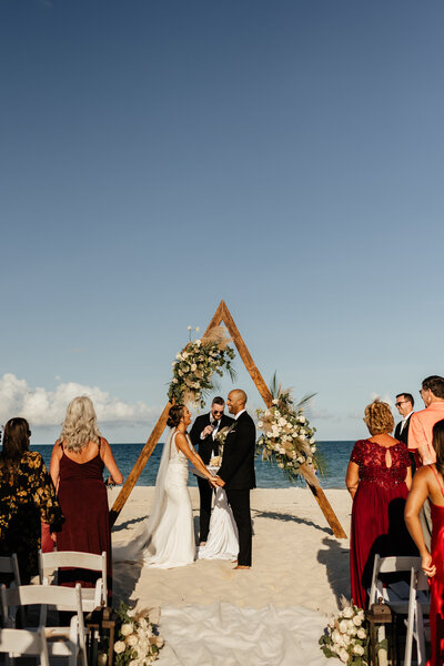 Bride and Groom standing on the beach during the ceremony