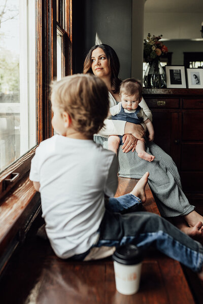 Photo of a mom with her two children staring out a window