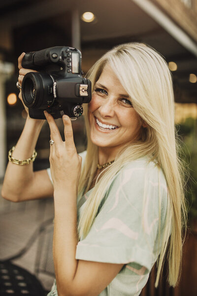 woman smiling holding camera