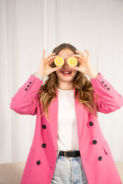 maiju holding lemon slices in front of her eyes laughing at the camera