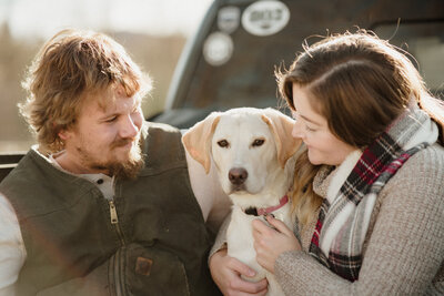 A couple with their beloved pet, capturing the special bond and the joy of a growing family in Vermont.