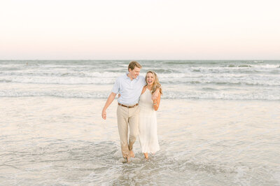 couple walking in the water on galveston beach