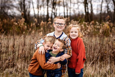 Family hugging and embracing each other in fall foliage.