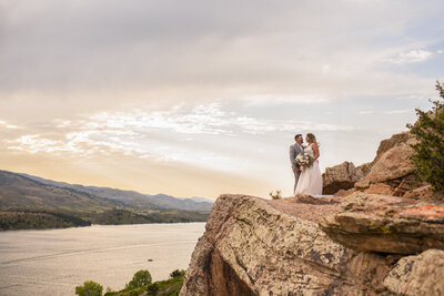 Newlyweds taking portraits off cliff on Fort Collins