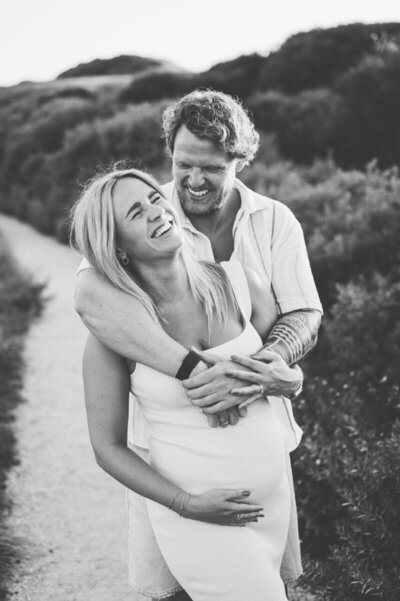 Zwangerschapshoot in Leiden buiten in de natuur van een man en vrouw die elkaar vasthouden.