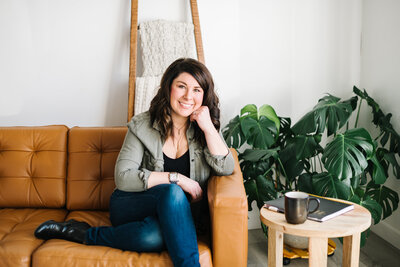 A smiling woman sitting on her living room couch